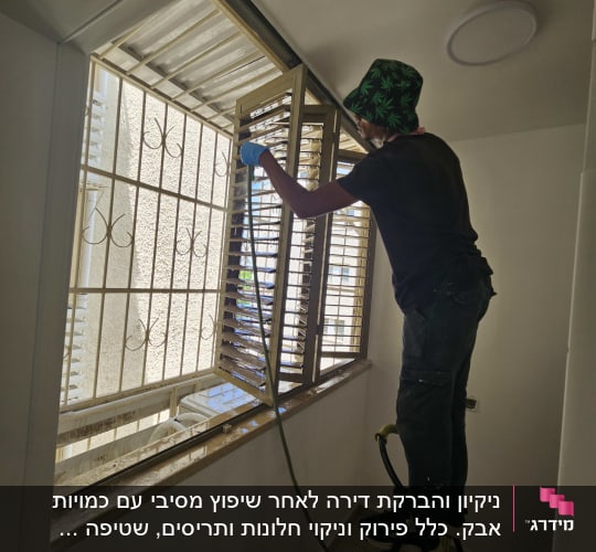 אדם מנקה חלון בעזרת צינור מים